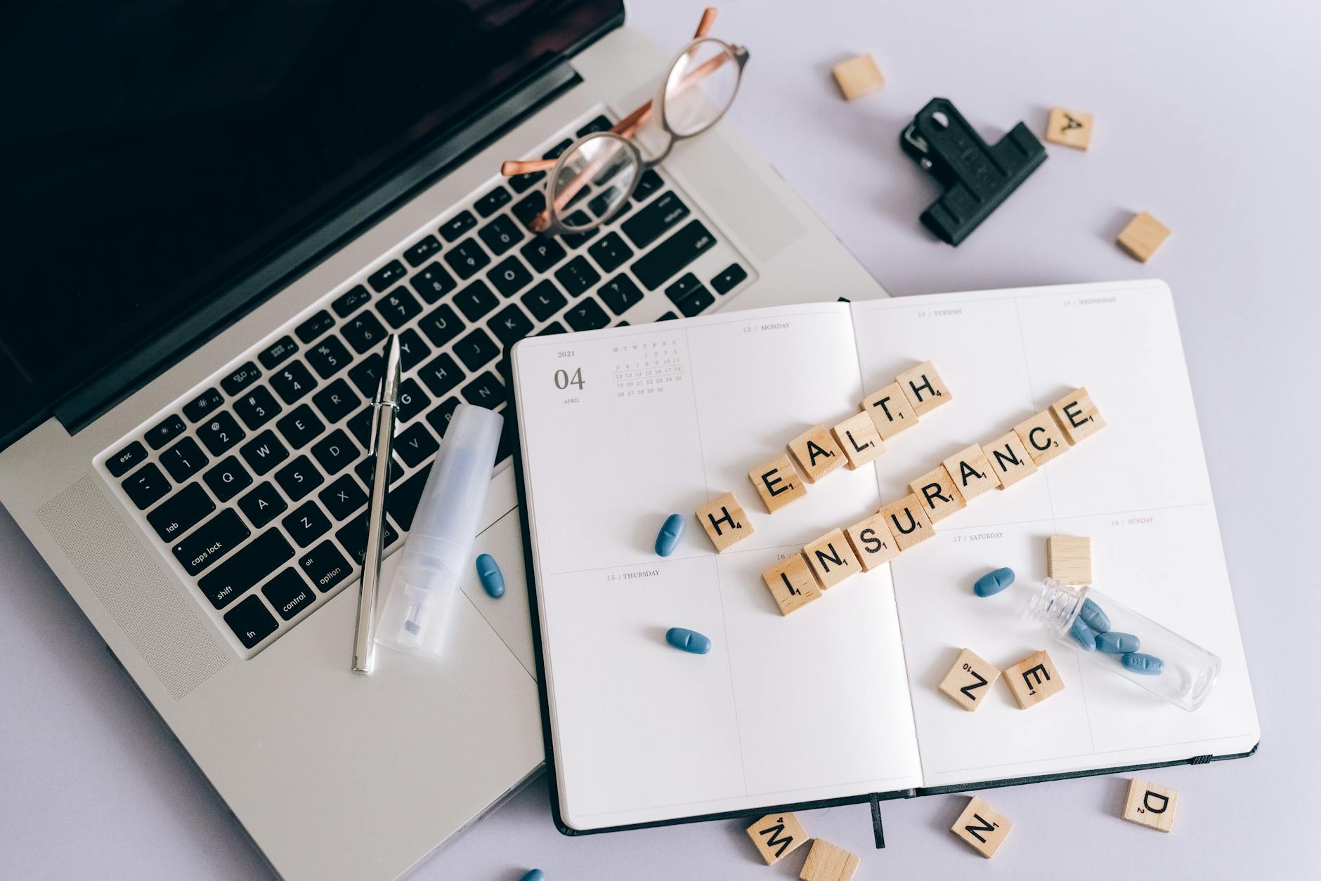 blue pills and scrabble tiles on a planner